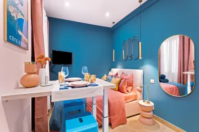 a blue living room with a table and a couch at Nice Renting - SPITALIERI - Chic & Cosy Art Deco Nest Nice Étoile in Nice