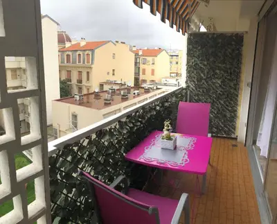 a pink table and chairs on a balcony at Royal Promenade in Nice