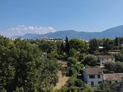 a view of a village with mountains in the background at entre terre et mer 3 pièces in Gattières