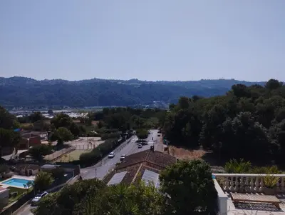 a view of a town with a street and trees at entre terre et mer 3 pièces in Gattières