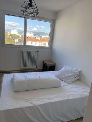 a white bed in a bedroom with two windows at Proche promenade des anglais in Nice