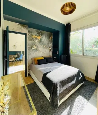 a bedroom with a large bed and a blue wall at Luxueux appartement, Carré d'Or, Square Mozart in Nice