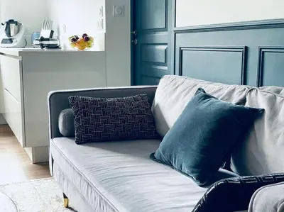 a couch with pillows on it in a living room at Luxueux appartement, Carré d'Or, Square Mozart in Nice