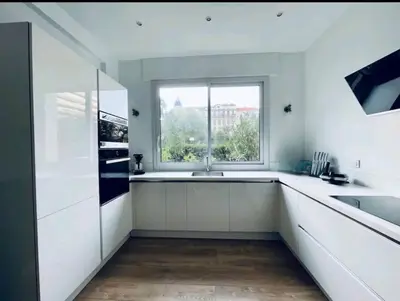 a white kitchen with a sink and a window at Luxueux appartement, Carré d'Or, Square Mozart in Nice