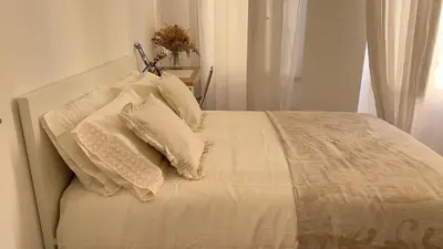 a bed with white sheets and pillows on it at Shared Duplex Apartment Nice-Port in Nice