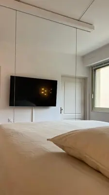 a bedroom with a bed with a flat screen tv on the wall at Beau studio au cœur de Beaulieu-sur-mer in Beaulieu-sur-Mer