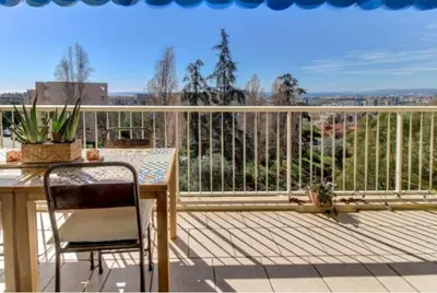 a balcony with a table and chair on a deck at Terrasses de la Corniche, 2p 65m2 spacieux, terrasses mer & montagne, piscine et parking privé in Nice
