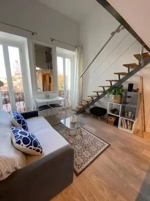 a living room with a couch and a staircase at Superbe Duplex avec vue ! in Villefranche-sur-Mer