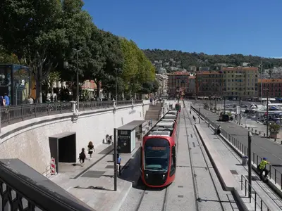 a red bus is parked at a train station at Apartment in Nice in Nice
