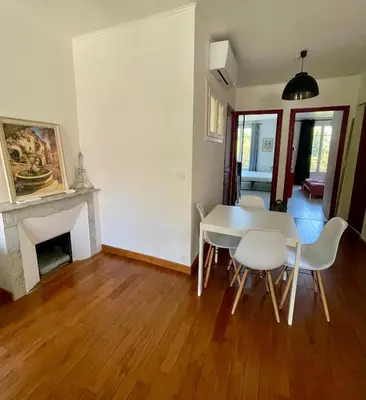 a dining room with a table and chairs and a fireplace at Spacieux appartement à Nice in Nice