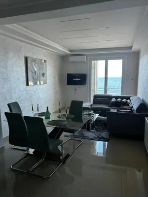 a living room with a table and a couch at Sea Front View - FRONT DE MER ET VUE PANORAMIQUE in Nice