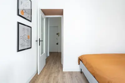 a bedroom with white walls and a bed and a hallway at Shopping et Détente au Centre Ville de Nice ! in Nice