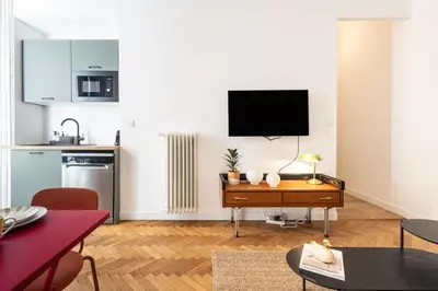 a living room with a flat screen tv on a wall at Shopping et Détente au Centre Ville de Nice ! in Nice