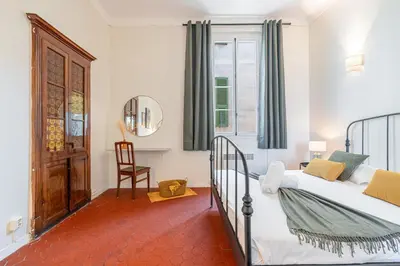 a bedroom with a bed and a chair and a window at 2 Bdr Panoramic View on Gardens in Nice