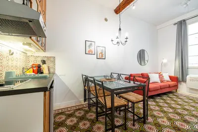 a living room with a table and a red couch at 2 Bdr with Independent Studio - Old Town in Nice
