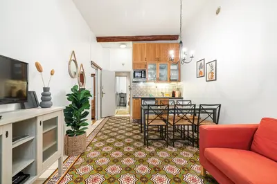 a living room with a red couch and a kitchen at 2 Bdr with Independent Studio - Old Town in Nice