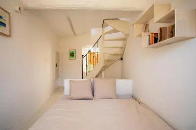 a room with a bed and a staircase at LA CASETTA DI AZZURRA AP4427 By Riviera Holiday Homes in Villefranche-sur-Mer