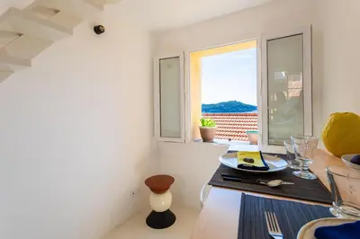a dining room with a table and a window at LA CASETTA DI AZZURRA AP4427 By Riviera Holiday Homes in Villefranche-sur-Mer