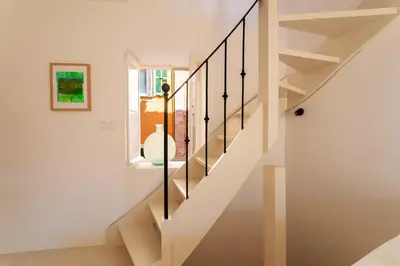 a white staircase with black railings in a house at LA CASETTA DI AZZURRA AP4427 By Riviera Holiday Homes in Villefranche-sur-Mer
