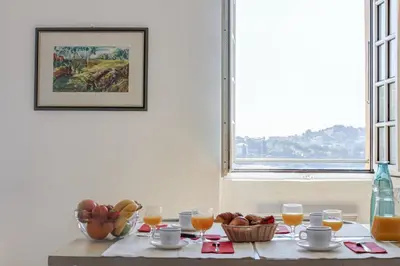 a table with a bowl of fruit and glasses of orange juice at Résidence Partenaire Le Palais de la Marine in Villefranche-sur-Mer