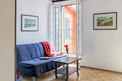 a blue couch in a living room with a table at Résidence Partenaire Le Palais de la Marine in Villefranche-sur-Mer