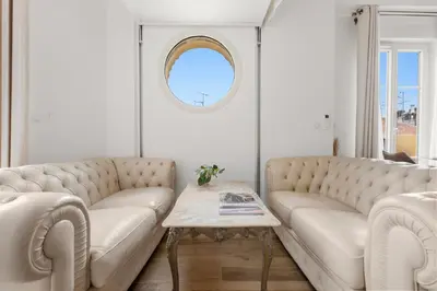 a living room with two white couches and a table at Appartement Gare Nice Ville in Nice