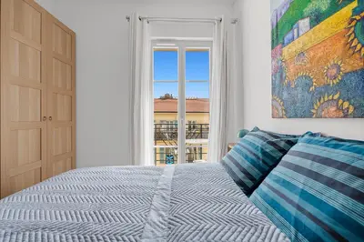 a bedroom with a bed and a large window at Appartement Gare Nice Ville in Nice