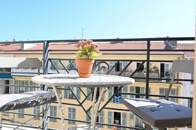 a table with a vase of flowers on top of a balcony at Appartement Gare Nice Ville in Nice