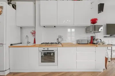 a kitchen with white cabinets and a wooden counter top at Appartement Gare Nice Ville in Nice