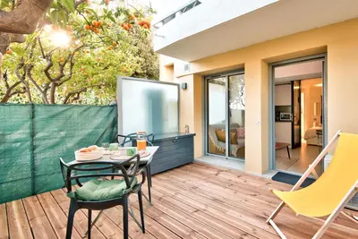 a patio with a table and chairs on a deck at Studio avec grande terrasse YourHostHelper in Villefranche-sur-Mer