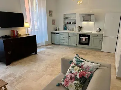 a living room with a couch and a kitchen at Rossetti Rosa Vieux Nice 2 bed in Nice