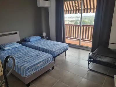 two beds in a room with a balcony at F2 ou F3 ,appartement climatisé neuf, magnifique vue sur mer et aéroport, proche tram et gare sncf 1 min,aéroport 3 minutes, 3 rooms, new AC apartment, magnificent sea and airport views, close to tram and SNCF train station 1 min, airport 3 min in Nice