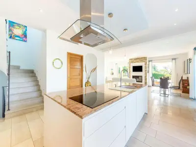 a kitchen with white cabinets and a counter top at CASA-Mathilda luxueuse villa moderne avec piscine in La Gaude
