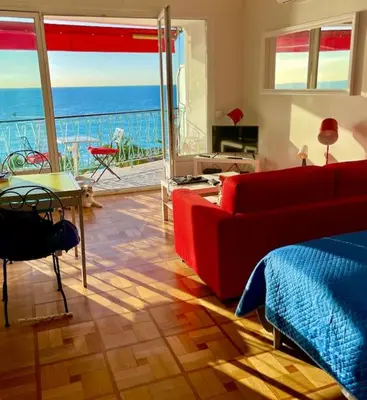 a living room with a red couch and a table at La Vague Bleue in Nice