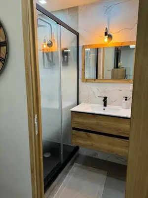 a bathroom with a sink and a glass shower at APPARTEMENt COSY in Nice