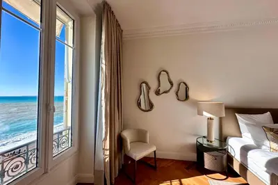 a bedroom with a bed and a window with the ocean at QUAI PROMENADE VIEW Sea View Balcony 3 Bedrooms Air Conditioning in Nice