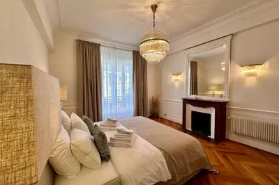 a bedroom with a bed with a fireplace and a chandelier at QUAI PROMENADE VIEW Sea View Balcony 3 Bedrooms Air Conditioning in Nice