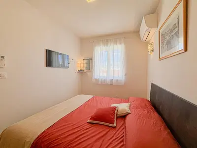 a small bedroom with a red bed with a window at Suite Zara - wifi, AC, 4 pers in Nice