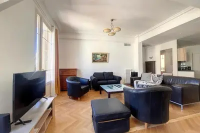 a living room with a couch and a tv at Bright air-conditioned flat in the city centre in Nice