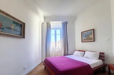 a bedroom with a bed and a window at Bright air-conditioned flat in the city centre in Nice
