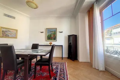 a dining room with a table and chairs and a window at Bright air-conditioned flat in the city centre in Nice