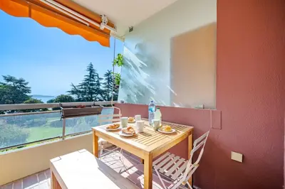 a table and chairs on a balcony with a view at Superbe 2 pièces Clim et Parking in Nice