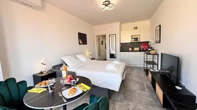 a bedroom with a bed and a table and a kitchen at Ze Perfect Place - Studio centre-ville - Masséna in Nice