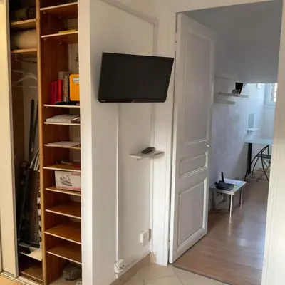 a living room with a tv and a closet at Chambre Nice hyper centre ville in Nice