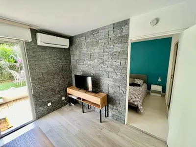 a bedroom with a brick wall and a desk with a television at Le Rieviera Bay-Parking-Jardin Pick up Airport in Saint-Laurent-du-Var
