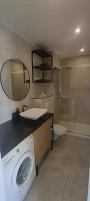 a bathroom with a sink and a washing machine at T2 vue imprenable au calme in Nice