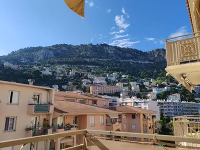 a living room with a dining room table and chairs at Charmant 3 pièces classé 3 etoiles en centre ville in Beaulieu-sur-Mer
