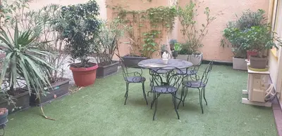 a patio with a table and chairs and potted plants at Studio Emmé neuf indépendant Nice Centre in Nice