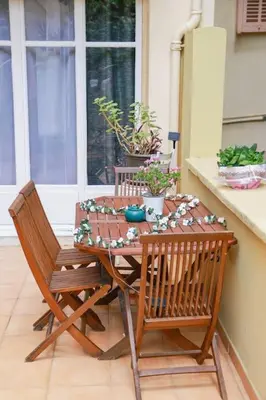 a table and chairs on a porch with plants at Cosy 3 pièces à 5 min de la PROM in Nice