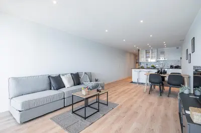 a living room with a gray couch and a kitchen at Panoramic Sea View - 1 Bdr Promenade des Anglais in Nice